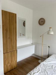 a bedroom with a bed and a clock on the wall at La Pléiade Dorée - Extra Centre - Wifi HD - Terrasse & Jardin in Amiens