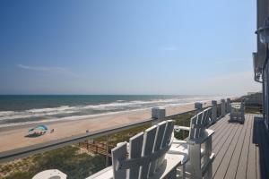 een uitzicht op het strand vanaf het balkon van een strandhuis bij Geaux Big in North Topsail Beach