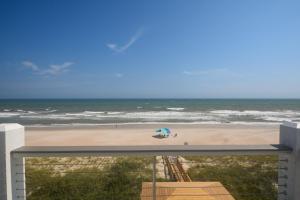 een uitzicht op een strand met een blauwe parasol bij Geaux Big in North Topsail Beach +76 foto's