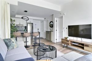 a living room with a couch and a flat screen tv at Penthouse, near old city in Quebec City