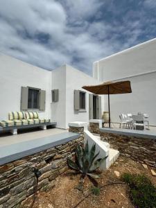 a white house with a patio with an umbrella at Comfortable apartment with sea view in Antiparos, 77 m² in Andiparos