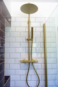 eine Dusche im Bad mit einer weißen Kachelwand in der Unterkunft The Wave Cottage - 3 Bedroom with off road Parking for 3 Cars or Vans & EV point in Pilning