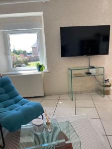 un salon avec un canapé bleu et une table en verre dans l'établissement NEW La ferme fleurie Gîte Ty Rose, à Ploubazlanec 23 autres photos