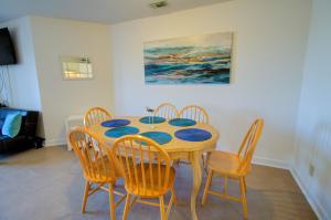 a dining room table and chairs with blue plates on it at Villa Capriani 109B in North Topsail Beach +23 photos