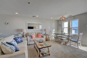 ein Wohnzimmer mit einer Couch und einem Klavier in der Unterkunft Villa Capriani 218A - Gone Coastal in North Topsail Beach