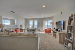 ein Wohnzimmer mit Sofa und Tisch in der Unterkunft Villa Capriani 218A - Gone Coastal in North Topsail Beach