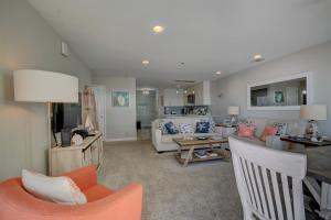 ein Wohnzimmer mit Sofa und Tisch in der Unterkunft Villa Capriani 218A - Gone Coastal in North Topsail Beach