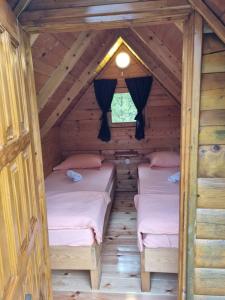 two beds in a room in a log cabin at Rafting Camp Modra Rijeka in &Scaron;ćepan-Polje