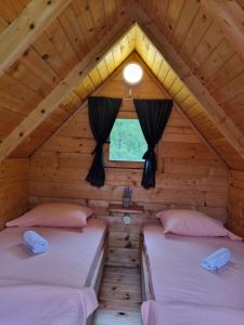 two beds in a room in a log cabin at Rafting Camp Modra Rijeka in &Scaron;ćepan-Polje
