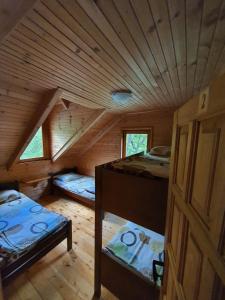 a room with two beds in a wooden cabin at Rafting Camp Modra Rijeka in &Scaron;ćepan-Polje