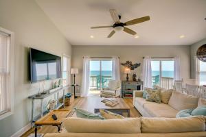 een woonkamer met een bank en een plafondventilator bij Beach Bunns in Surf City