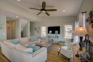 een woonkamer met een witte bank en een plafondventilator bij Beach Bunns in Surf City