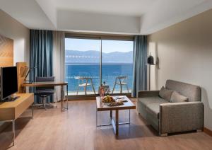 a living room with a couch and a view of the ocean at Liberty Kuşadası in Kuşadası