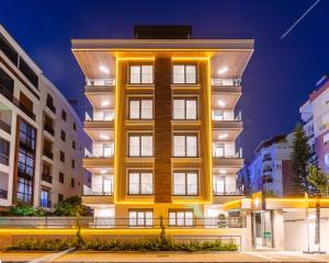 a tall yellow building in a city at night at Los Suites in Antalya