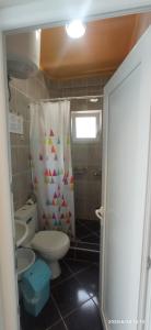 a bathroom with a toilet and a shower curtain at Apartmani Isabela sa terasom in Zagrađe
