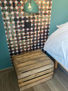 a bed with a wooden bench next to a wall at Appartement Thout dichtbij zee in Ostend