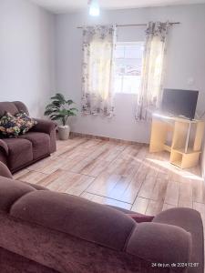 ein Wohnzimmer mit Sofa und Tisch in der Unterkunft casa da Dora próx da praia in Caraguatatuba + 13 Fotos