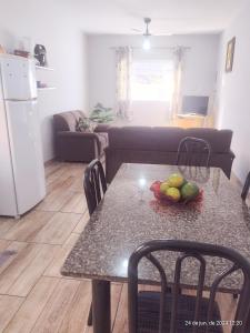eine Küche mit einem Tisch mit einer Obstschale darauf in der Unterkunft casa da Dora próx da praia in Caraguatatuba