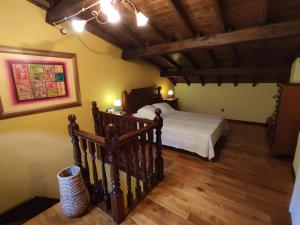 a bedroom with a bed and a wooden floor at Casa de Aldea CASA MON in Levinco