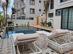 a patio with chairs and a swimming pool at DBD Hotel Çeşme in Yumru