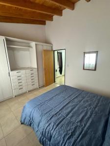 a bedroom with a large bed with a blue blanket at Refugio Andino 2 in Malargüe