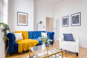 un sofá azul y una silla blanca en la sala de estar en Sloane House, en Birmingham
