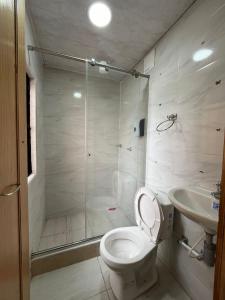 a bathroom with a shower and a toilet and a sink at HOTEL BS in Nemocón