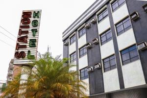 a building with a hotel sign and a palm tree at Station Hotel (Adults Only) in Rio de Janeiro