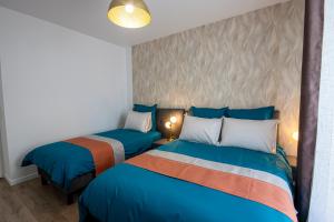 two beds in a room with blue at Appartement cosy aux portes de Disney in Chessy