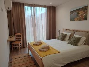 a bedroom with a large white bed with two pillows on it at Quinta do Tojo in Alufinha +63 photos