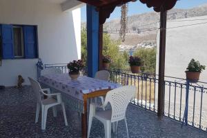 a table and chairs on a balcony with a view at Kalotina's House in Telendos