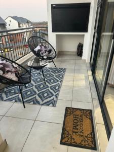 プレトリアにあるThe Blyde Lagoon Apartmentのバルコニー(椅子2脚、薄型テレビ付) +3枚の写真