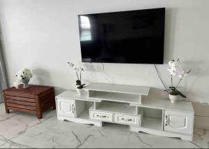 a white entertainment center with a flat screen tv on a wall at ABSOLUTE BEACHFRONT Port Stephens - Pindimar Beach House in Pindimar