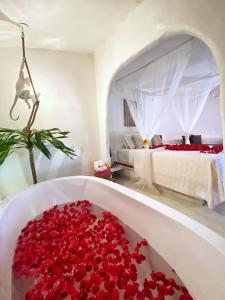 a bath tub filled with red roses in a bedroom at Pousada Ilha do Vento in São Miguel do Gostoso +64 photos