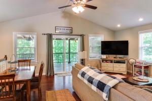 un salon avec un canapé, une table et une télévision dans l'établissement Riverfront Cottage Near Rock Island State Park, à Doyle
