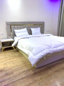 Ένα ή περισσότερα κρεβάτια σε δωμάτιο στο شقة فندقية داخل بيفرلي هيلز الشيخ زايد رقم هاتف صفر صفر اتنين صفر واحد واحد صفر اتنين اربعه ثلاثه صفر 222