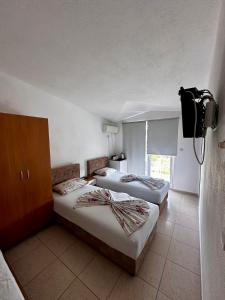 a hotel room with two beds and a tv at Apartmani ARIANA in Dobra Voda