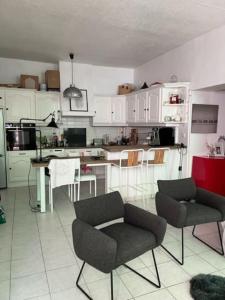 a kitchen with white cabinets and a table and chairs at Appartement centre ville avec Patio in Marseille