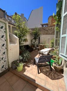 a patio with a chair and a table with plants at Appartement centre ville avec Patio in Marseille