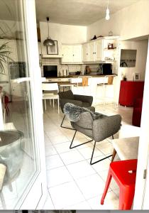 a living room and kitchen with a couch and chairs at Appartement centre ville avec Patio in Marseille