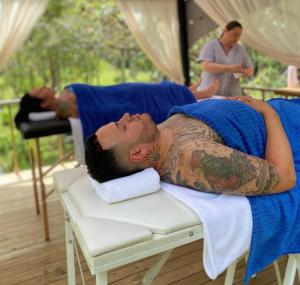a man with a tattoo laying on a bed at Chapola Home in Guarne