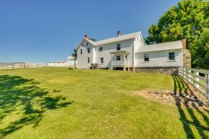 a white house with a fence on a grass field at Historic Jefferson Farmhouse - Hike, Bike and Raft! in Jefferson