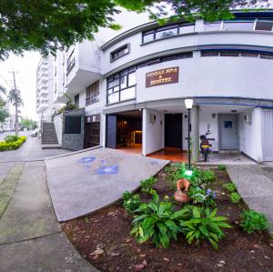 a white building with a sign on it at NOGAL SPA & HOSTEl in Pereira