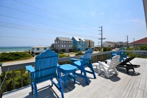 a deck with blue and white chairs and the ocean at 1 Grandview in Surf City