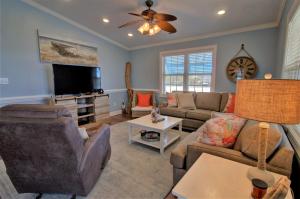 un soggiorno con un divano e una TV di Beach Therapy a Surf City