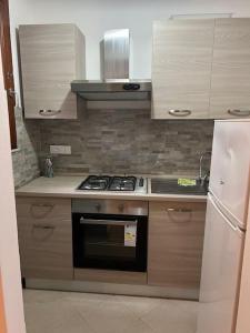 a kitchen with a stove and a refrigerator at Casa Ondea in Marina di Pisa