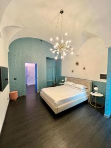 sypialnia z łóżkiem i żyrandolem w obiekcie Room Verona Ai Conti w Weronie