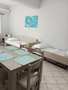 a living room with a table and a bed at Lefakis Aegean Breeze Apartment in Órmos
