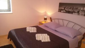 a bedroom with a bed with purple sheets and a lamp at Apartments Roncevic in Zadar