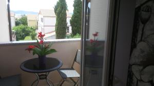 a table with a vase of flowers on a balcony at Apartments Roncevic in Zadar